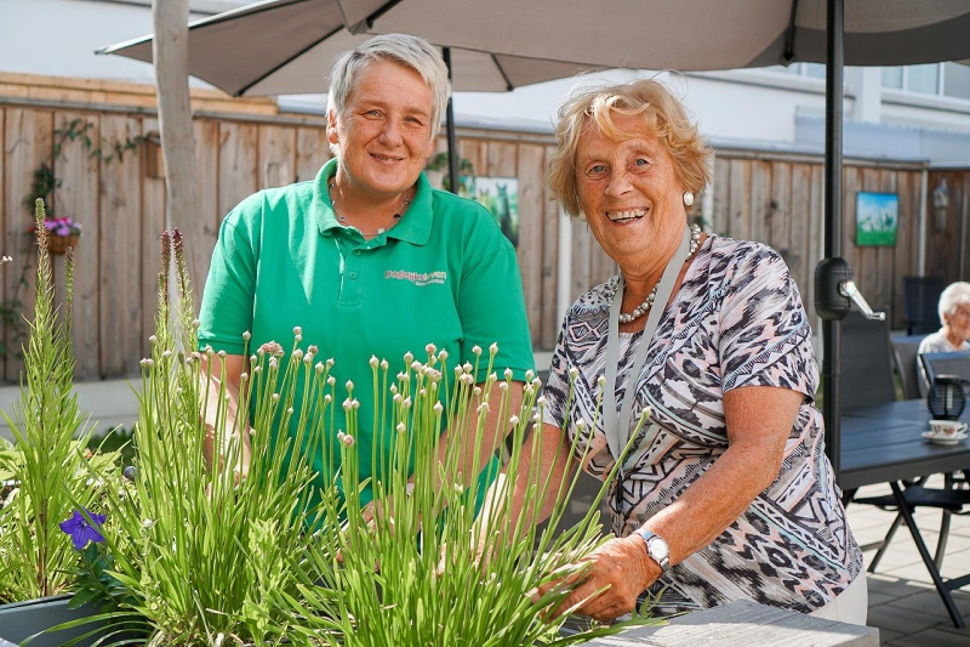 een man en een vrouw achter een pot planten